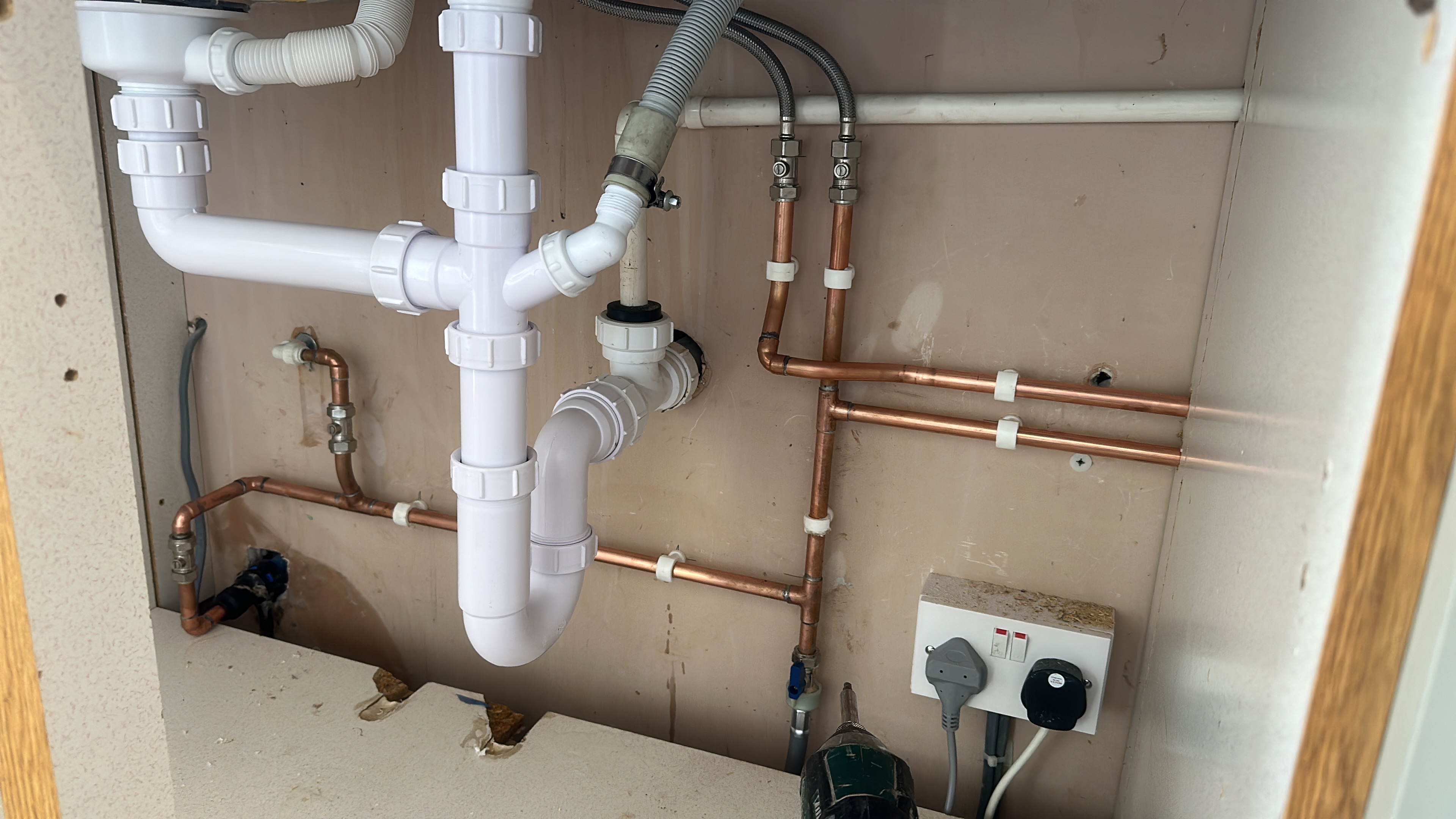 Copper hot and cold pipework beneath a sink