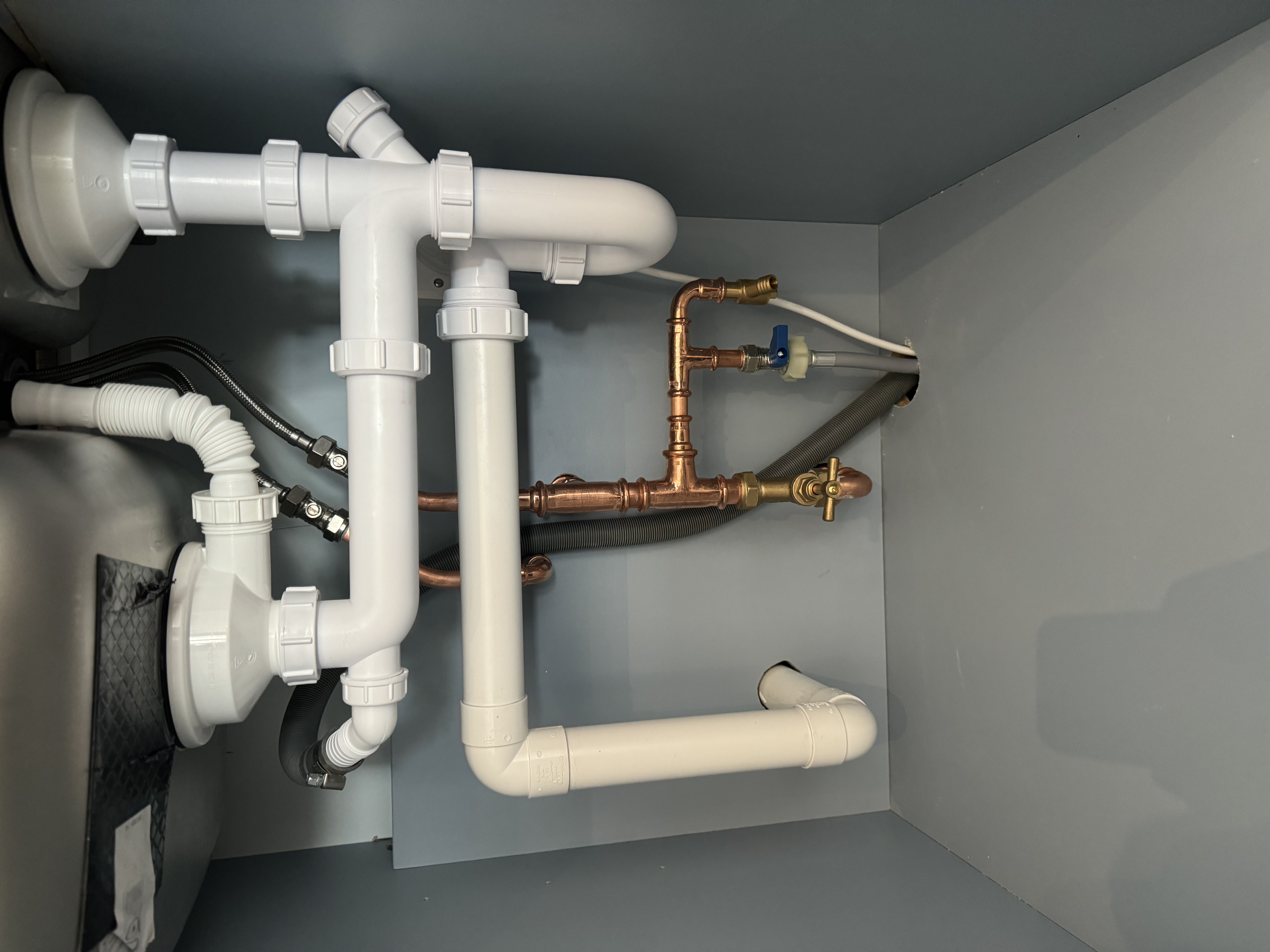 Neatly installed plumbing beneath a sink